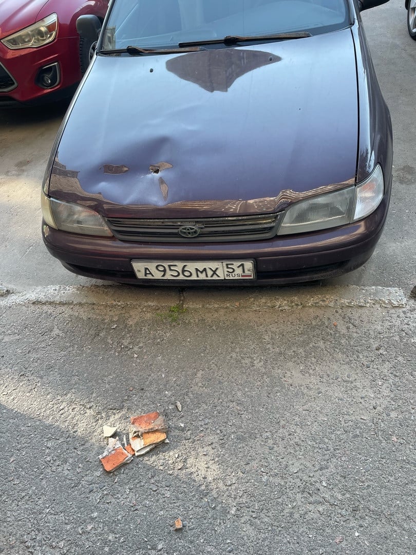 Кусок штукатурки пробил капот машины в Мурманске