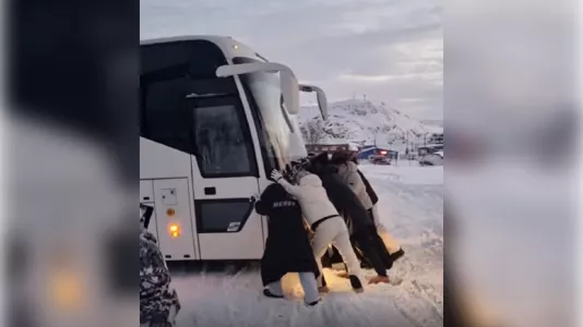 Китайские туристы помогали северянам выталкивать из снега автобус в Териберке